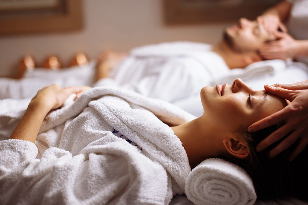 Couple in spa getting massages, relaxing in spa