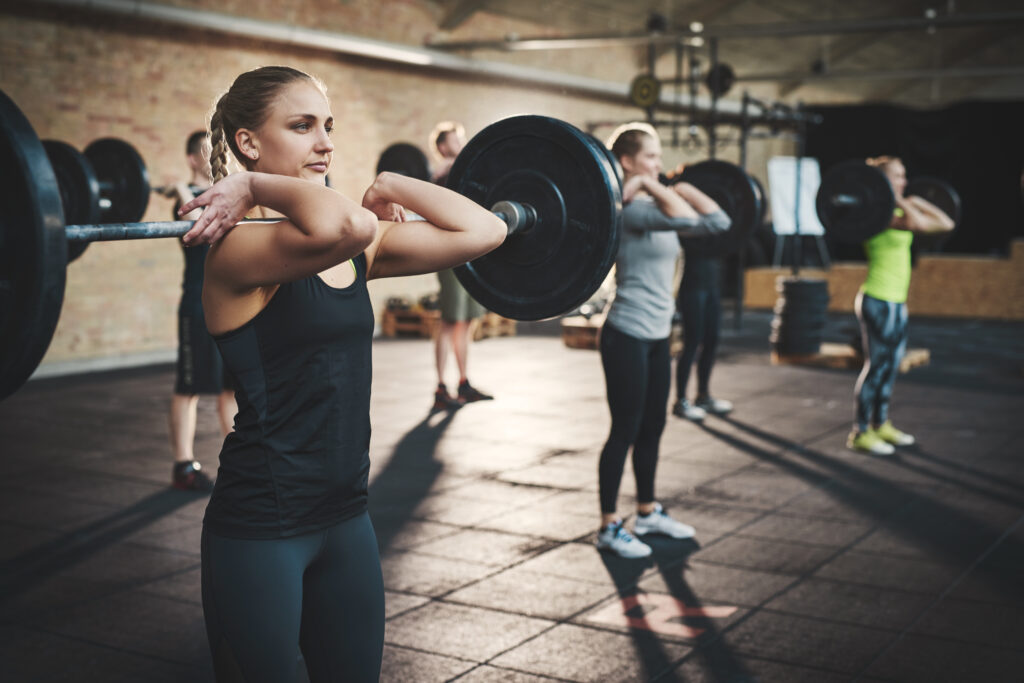 Three women lifting weights during a group fitness class.