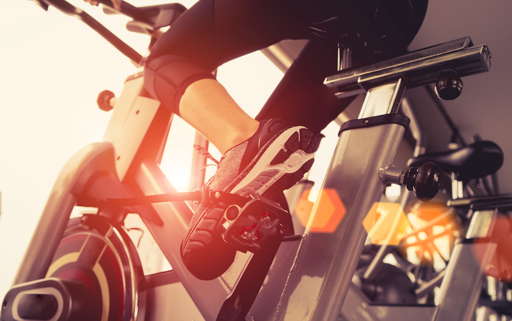 A woman on a cycle bike in her group fitness class