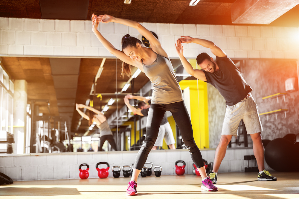 Two athletes doing side stretches