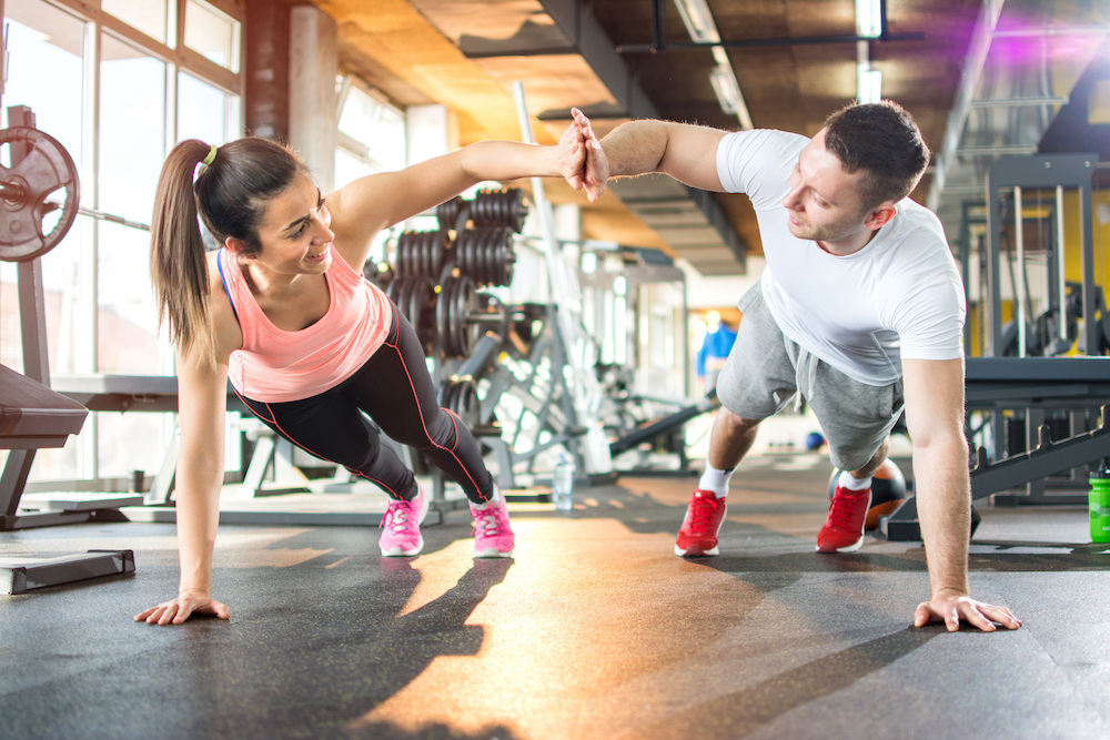 Two friends high-fiving during a workout