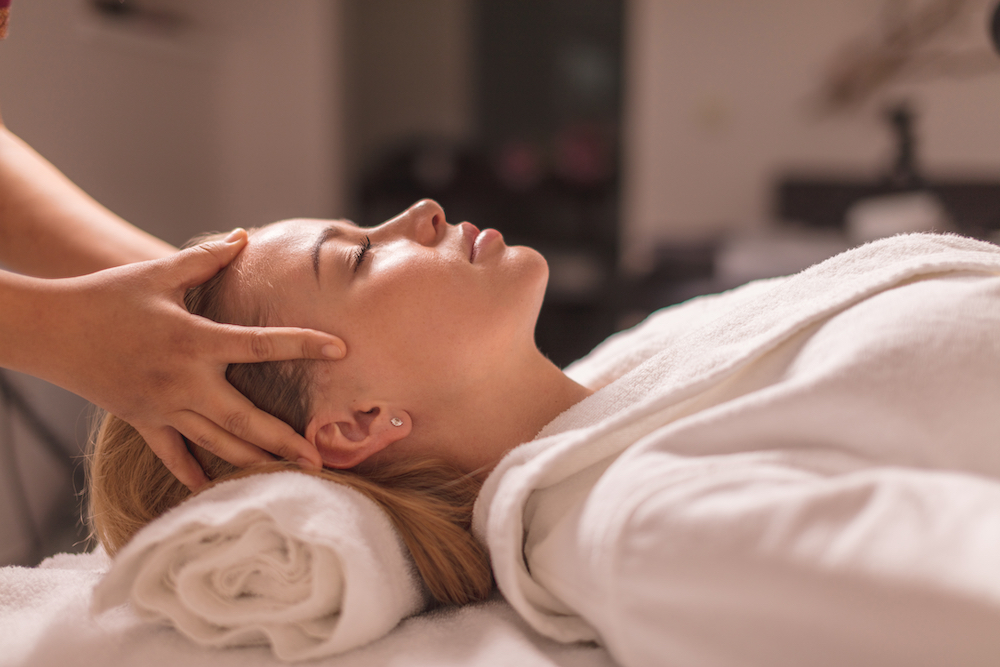 A woman getting a neck and scalp massage