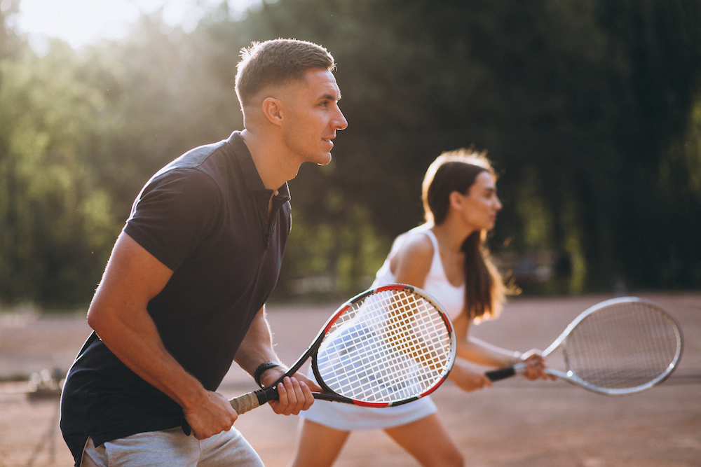 A fit young couple playing tennis together
