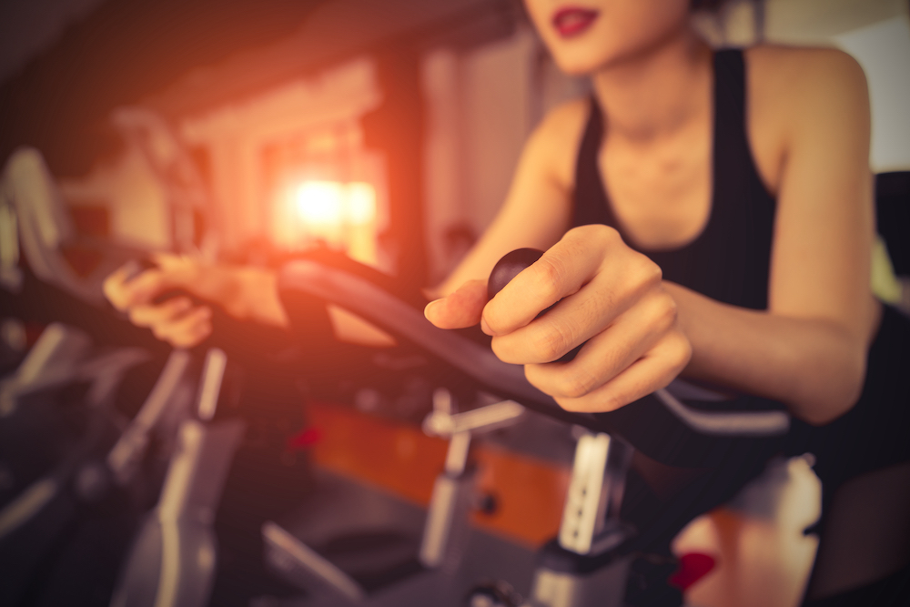 A young, fit woman taking a cycling class