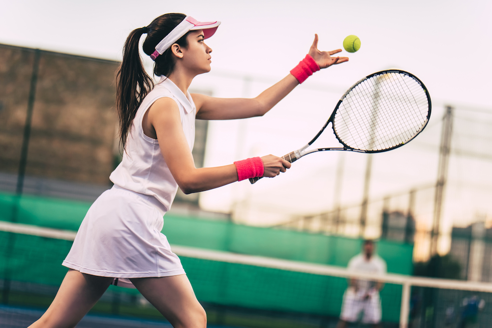 A young woman prepares to take a swing at the ball during her adult tennis lessons in Kansas City