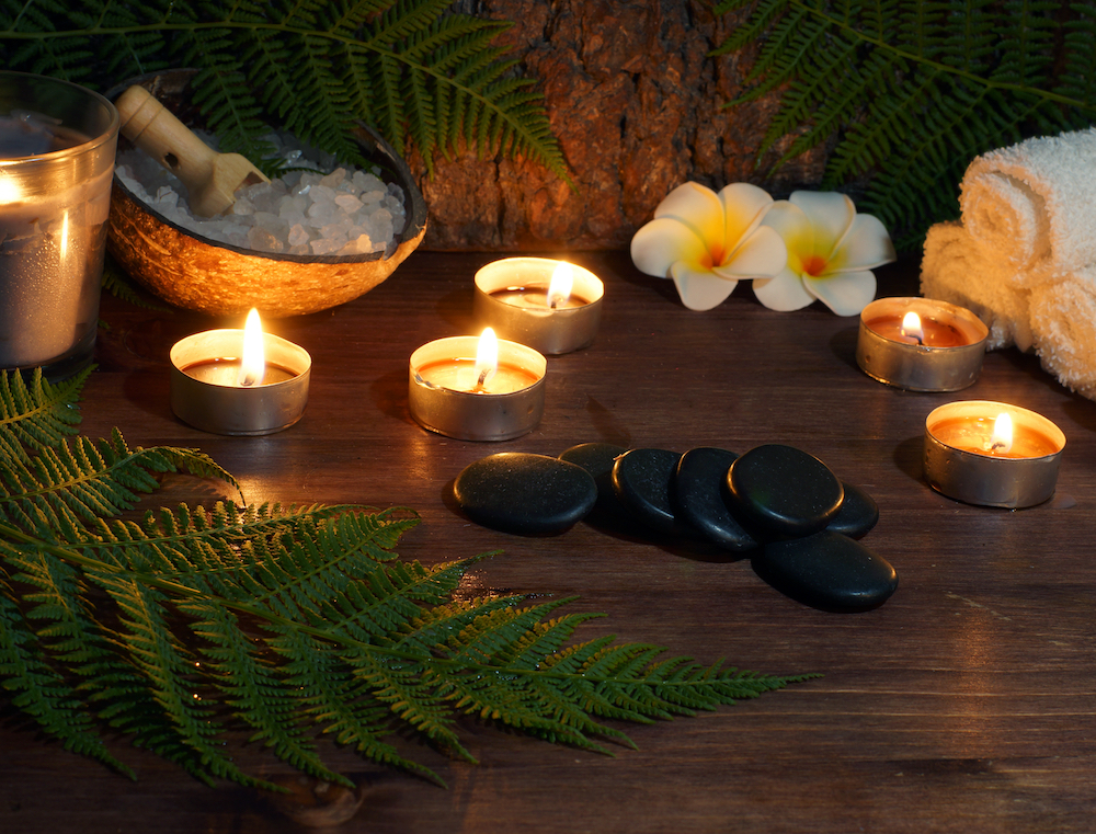 Hot stones, flowers, and candles set up in a spa room
