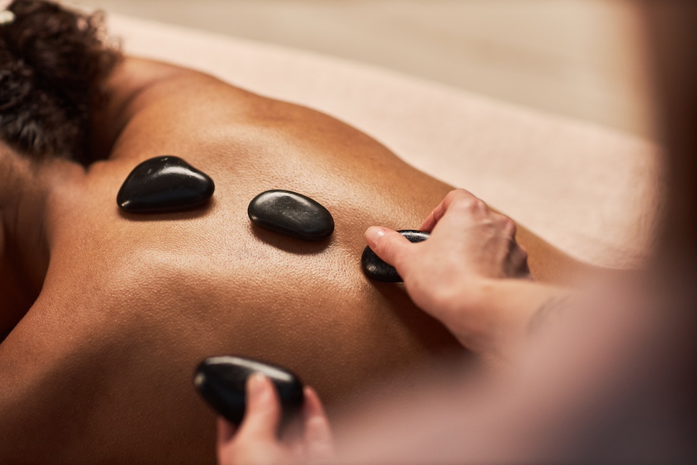 A woman getting a hot stone massage at the wellness center in Kansas City