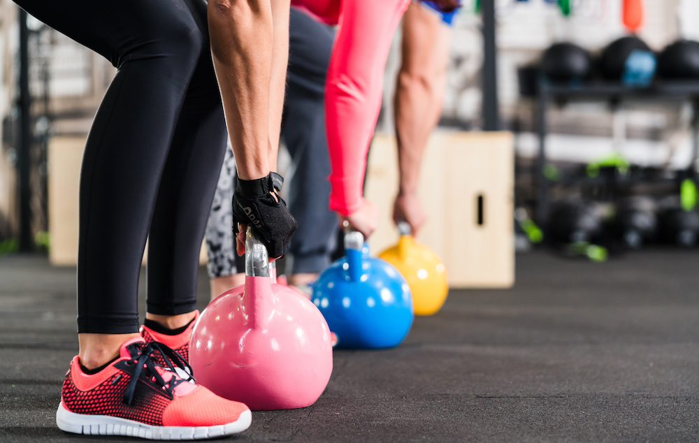 A group of individuals using kettle bells at the workout classes in Kansas City