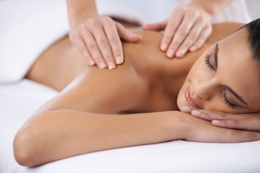 Woman gets back massage from massage therapists in Kansas City.