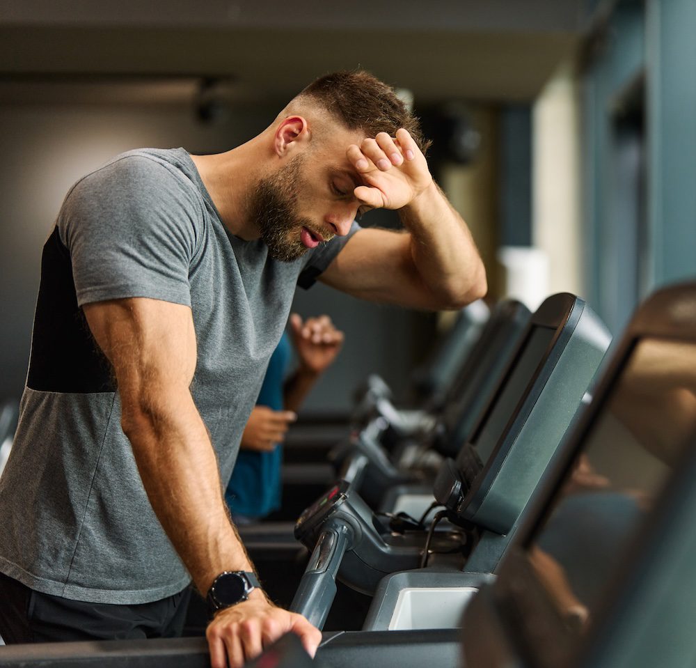 Young man on treadmill struggling with his fitness classes kansas city